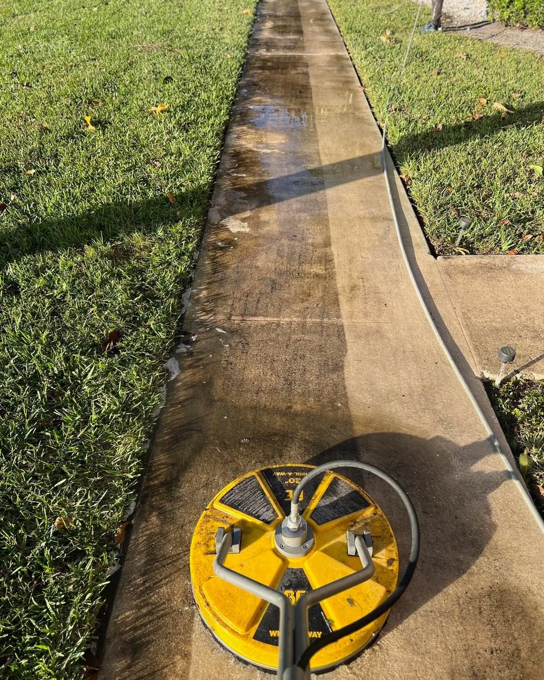 Rotary pressure cleaner on driveway